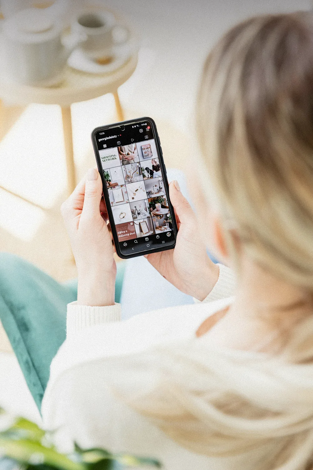 Akıllı telefonda Instagram profil ızgarasını inceleyen kişi