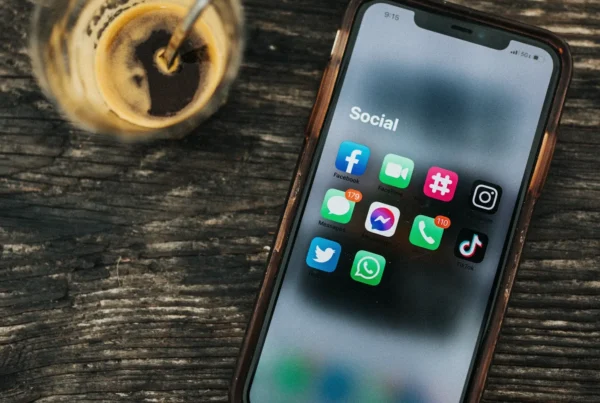 Ahşap masada sosyal medya uygulamaları açık akıllı telefon