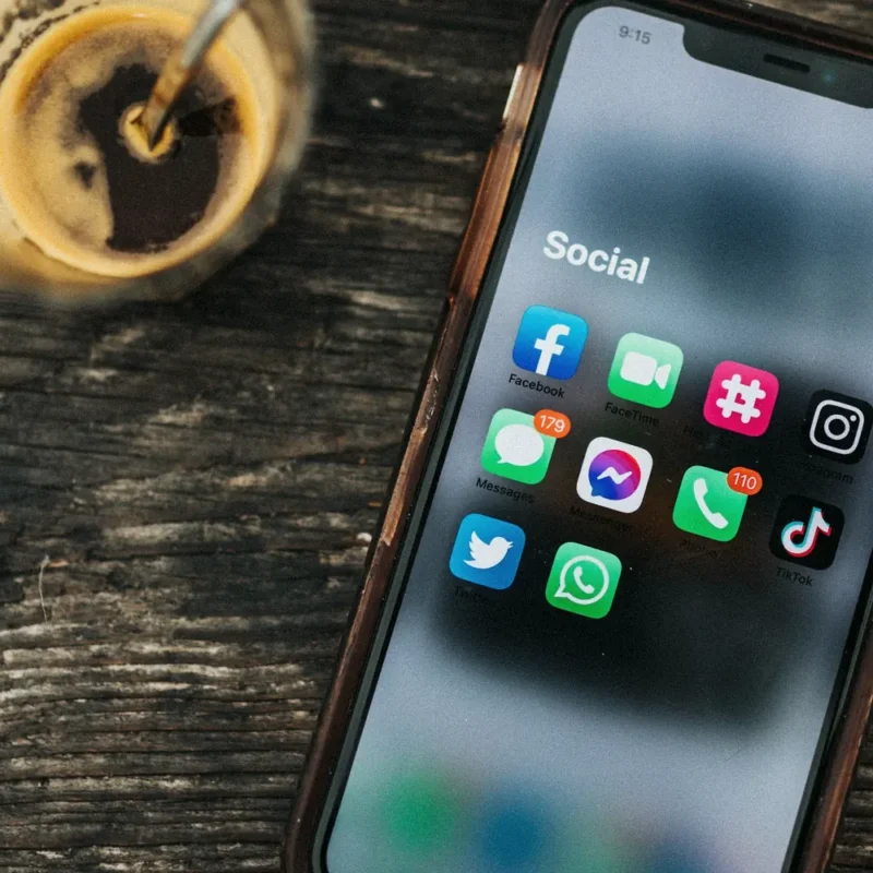 Ahşap masada sosyal medya uygulamaları açık akıllı telefon