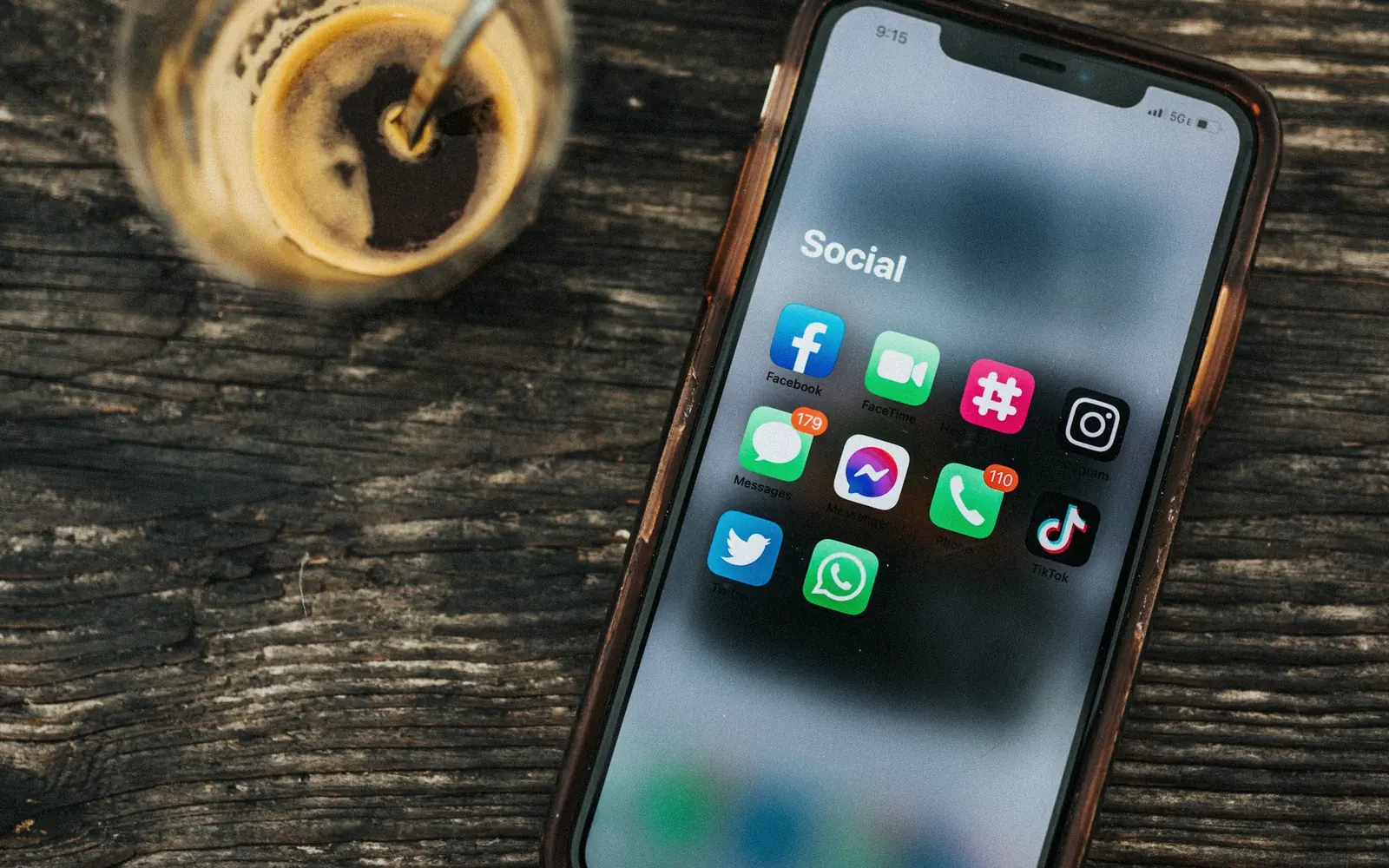 Ahşap masada sosyal medya uygulamaları açık akıllı telefon